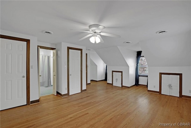 bonus room with light wood-style floors, visible vents, a ceiling fan, and baseboards