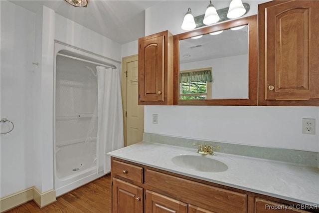 bathroom with wood finished floors, vanity, and curtained shower