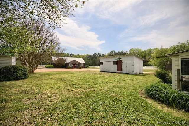 view of yard featuring an outdoor structure and fence