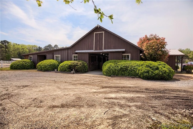 view of front of house featuring fence, an outbuilding, and a barn