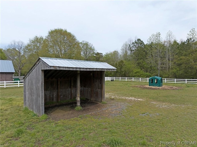 view of pole building with fence, a lawn, and a carport
