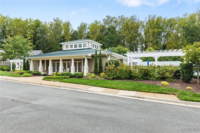 view of front of house featuring metal roof, a pergola, french doors, and a standing seam roof