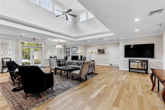 living area featuring ceiling fan, visible vents, plenty of natural light, and light wood-style flooring
