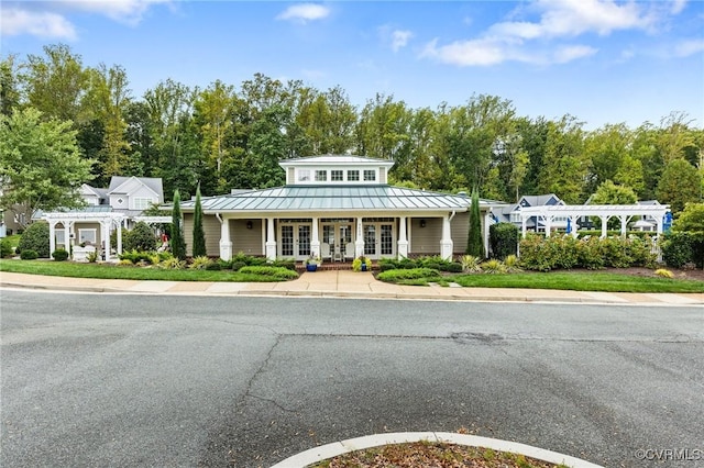 view of front facade with a pergola, a standing seam roof, french doors, and metal roof