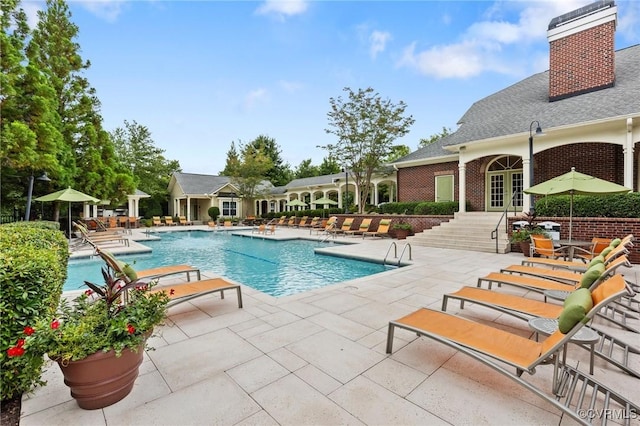 community pool with a patio area and french doors