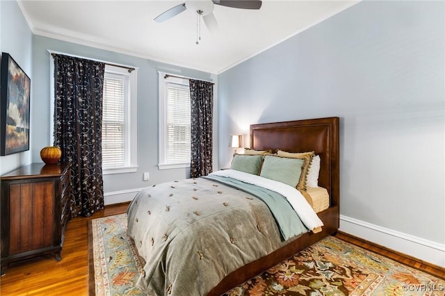 bedroom featuring baseboards, ornamental molding, and wood finished floors