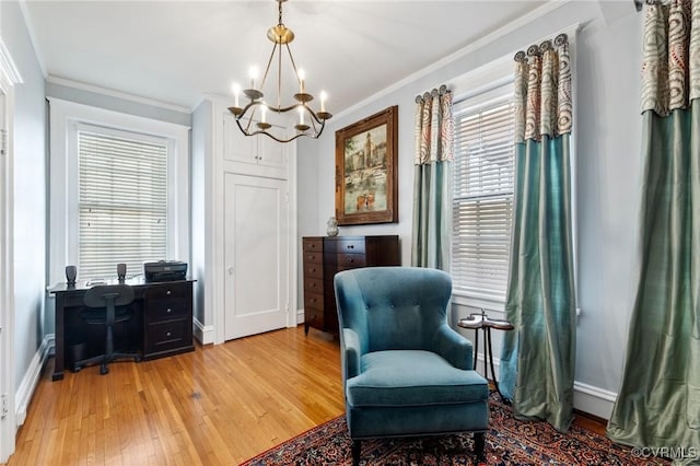 living area featuring light wood-style floors, baseboards, ornamental molding, and a chandelier