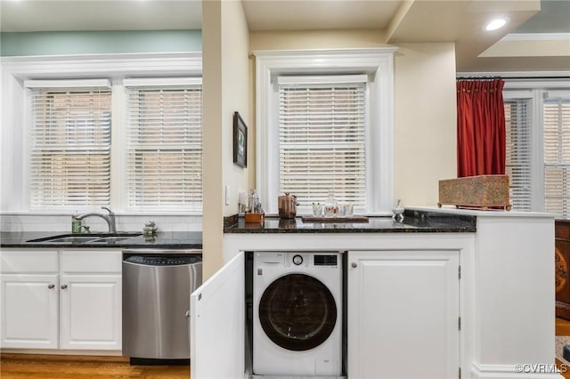 laundry area featuring laundry area, a sink, washer / dryer, and a wealth of natural light