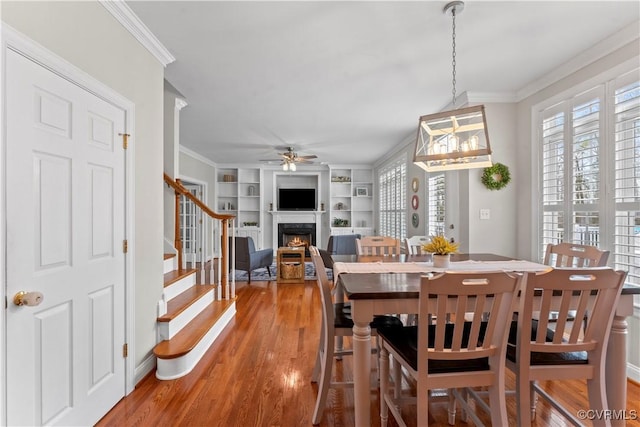 8500 Baldwin Creek Rd, Chesterfield, VA 23832 - dining space featuring crown molding, ceiling fan, stairs, light wood-type flooring, and a lit fireplace