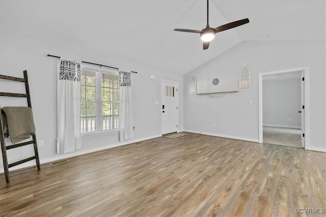 unfurnished living room with baseboards, a ceiling fan, wood finished floors, and vaulted ceiling