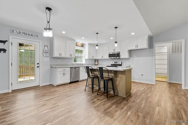 kitchen featuring light wood finished floors, appliances with stainless steel finishes, and white cabinets