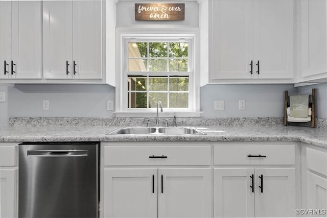 kitchen with stainless steel dishwasher, a sink, white cabinetry, and light countertops