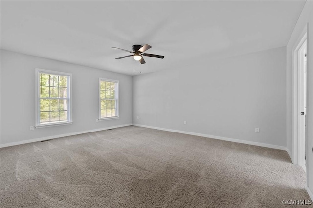 spare room with baseboards, ceiling fan, carpet floors, and visible vents