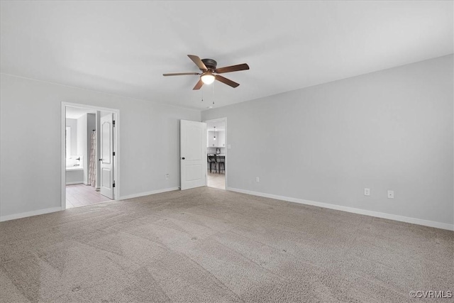 interior space with light colored carpet, a ceiling fan, and baseboards