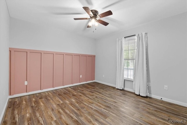spare room with baseboards, a ceiling fan, and wood finished floors