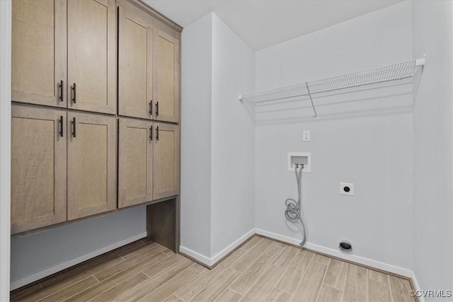 laundry room featuring cabinet space, hookup for an electric dryer, light wood finished floors, and hookup for a washing machine