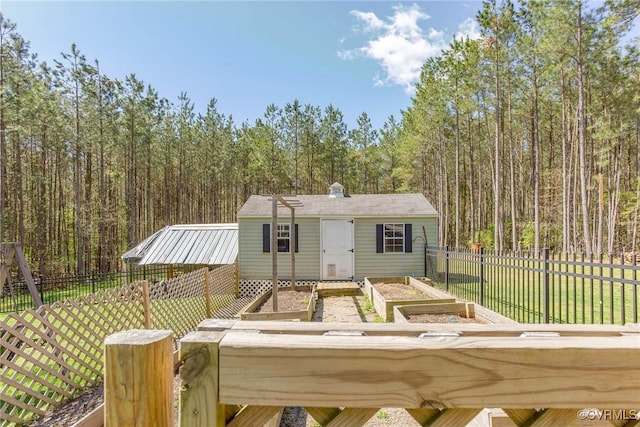 6360 Haleford Dr, Powhatan, VA 23139 - exterior space featuring a wooded view, an outbuilding, a fenced backyard, a front lawn, and a vegetable garden