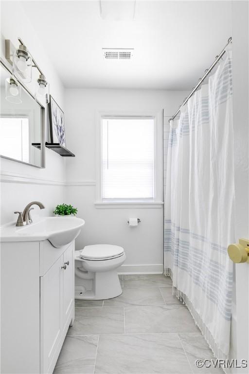bathroom with toilet, visible vents, curtained shower, and vanity