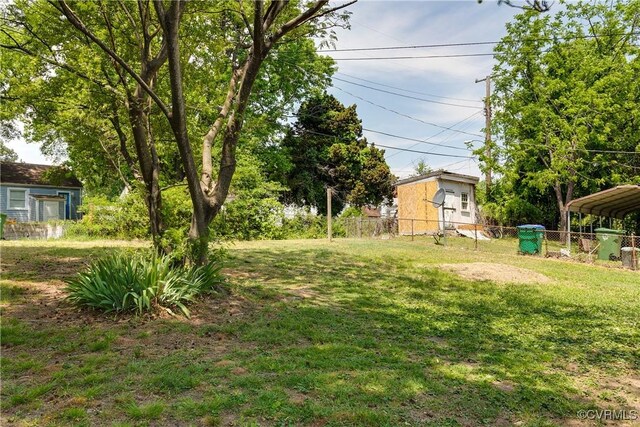 view of yard featuring fence and a carport