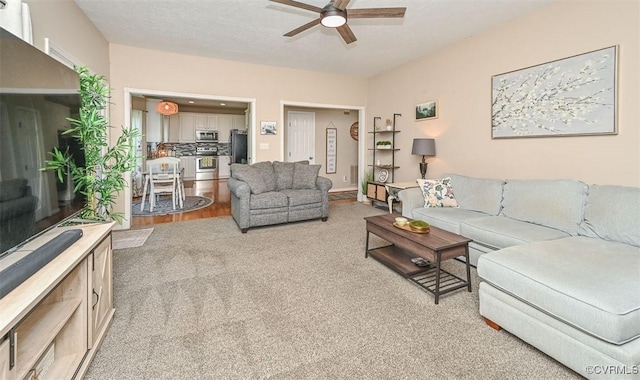 living room with ceiling fan and light carpet