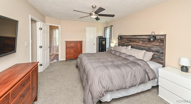 carpeted bedroom with a textured ceiling and ceiling fan
