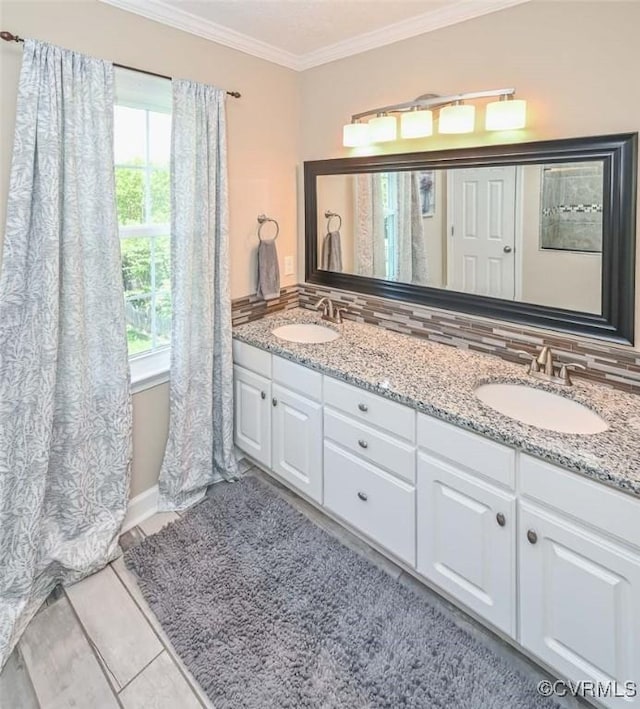 full bath featuring a sink, ornamental molding, backsplash, and double vanity