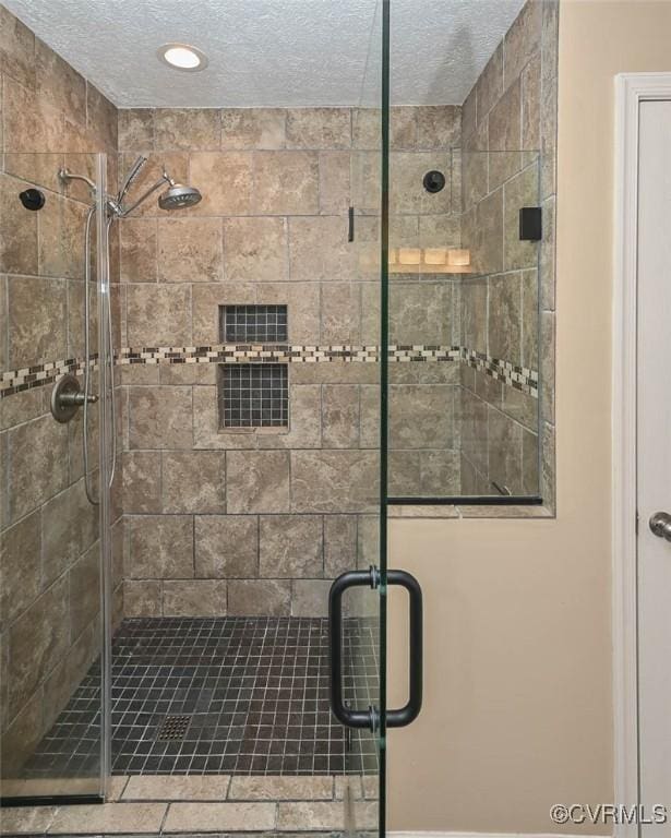 full bathroom with recessed lighting, a textured ceiling, and a stall shower