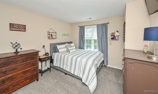 bedroom featuring a textured ceiling, baseboards, visible vents, and light carpet