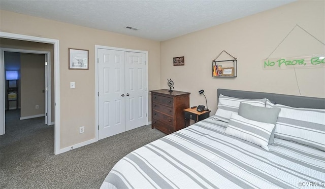 bedroom with visible vents, a closet, baseboards, dark carpet, and a textured ceiling