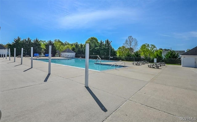 pool with a patio area and fence