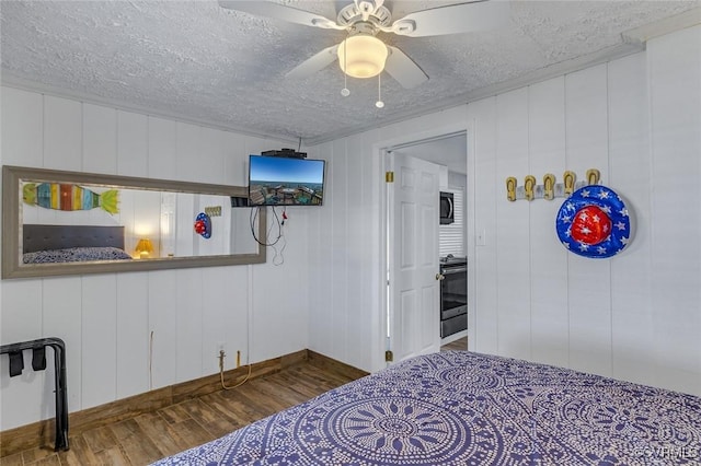 bedroom featuring baseboards, a ceiling fan, wood finished floors, and a textured ceiling