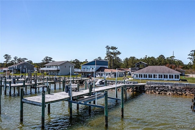 dock area with a residential view, boat lift, and a water view