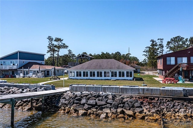 view of dock with a lawn, a water view, and stairway