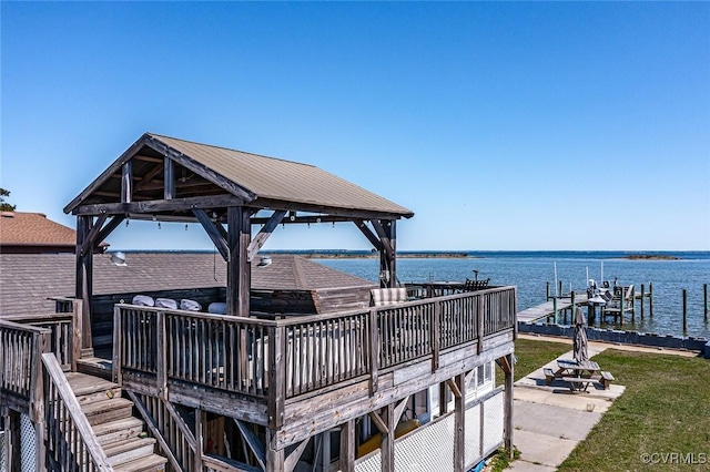 view of dock with a gazebo, a yard, a deck with water view, and stairway