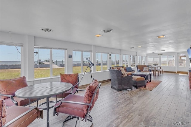 sunroom featuring visible vents and a healthy amount of sunlight
