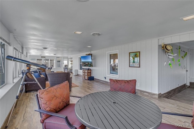 interior space with baseboards, wood finished floors, and visible vents