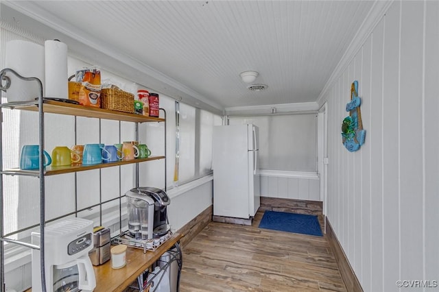 interior space featuring wood finished floors, visible vents, and crown molding