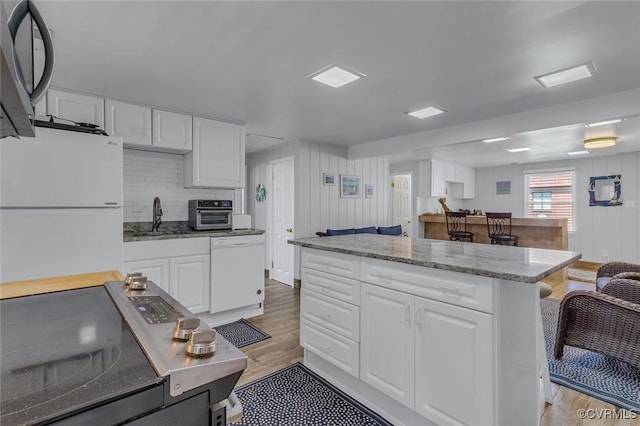 kitchen with white cabinets, light wood-style floors, a sink, and white appliances