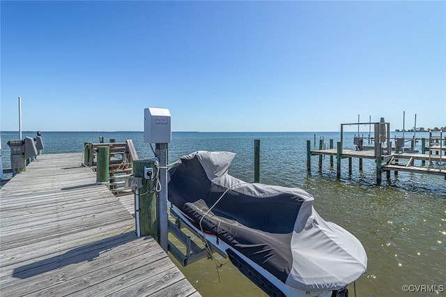 view of dock with boat lift and a water view