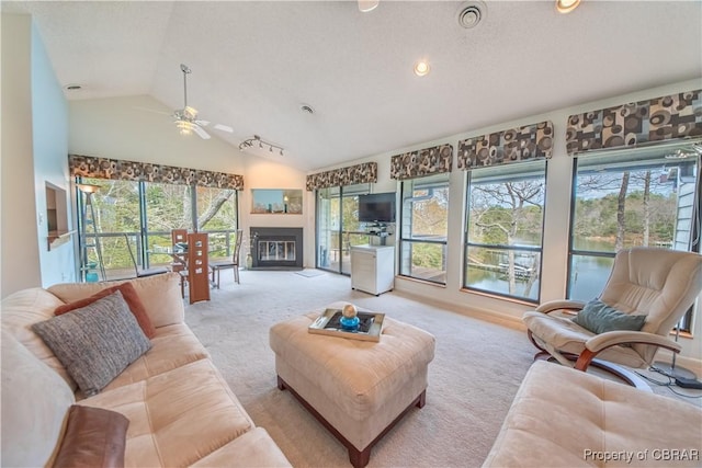 carpeted living room with lofted ceiling, a ceiling fan, a glass covered fireplace, and recessed lighting