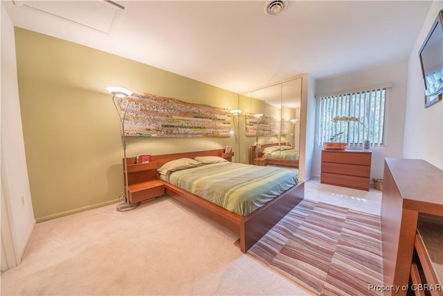 bedroom featuring attic access, baseboards, visible vents, and carpet