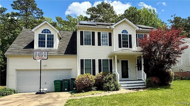 view of front facade featuring roof mounted solar panels, driveway, a front yard, and a garage