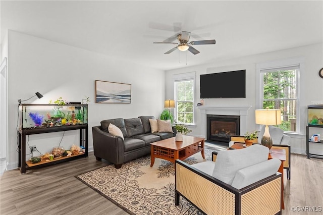 5530 Tyshire Pkwy, Providence Forge, VA 23140 - living room featuring ceiling fan, light wood-style flooring, a glass covered fireplace, and baseboards