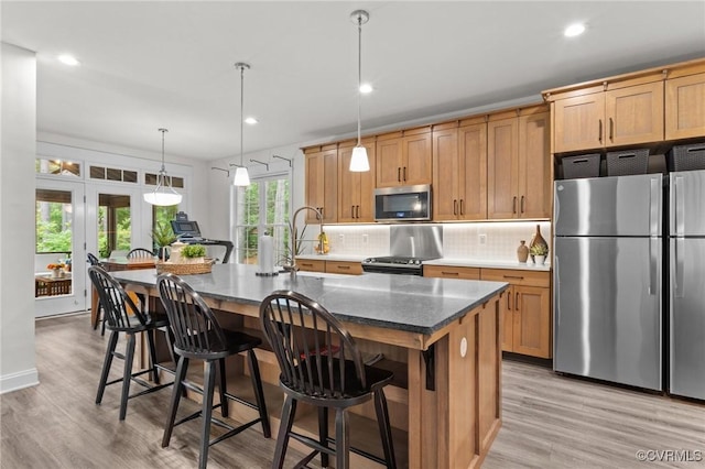 5530 Tyshire Pkwy, Providence Forge, VA 23140 - kitchen featuring appliances with stainless steel finishes, a kitchen island with sink, light wood-style flooring, tasteful backsplash, and recessed lighting