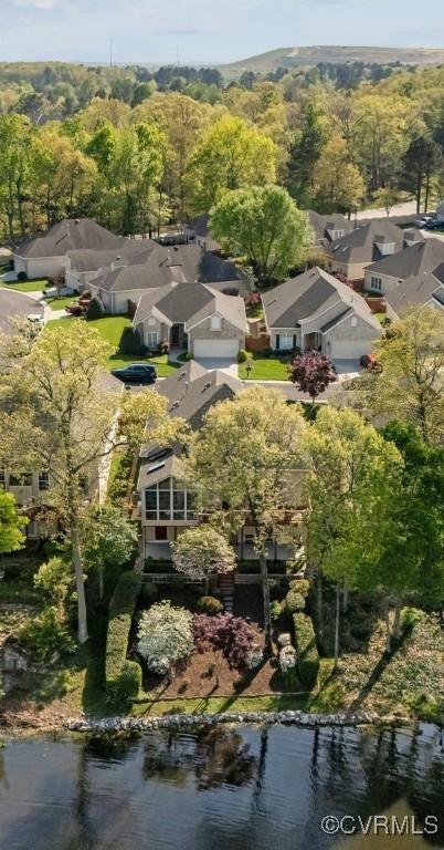 drone / aerial view with a forest view, a water view, and a residential view