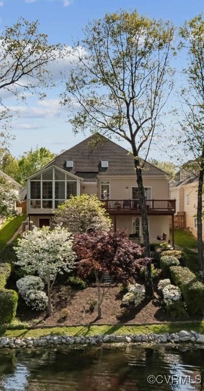 rear view of house featuring a sunroom and a deck