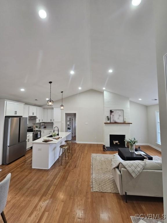 3109 Comet Rd, Richmond, VA 23294 - living area featuring a fireplace, recessed lighting, baseboards, wood finished floors, and vaulted ceiling