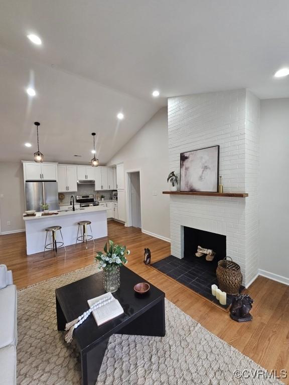 3109 Comet Rd, Richmond, VA 23294 - living room with baseboards, dark wood finished floors, lofted ceiling, and a fireplace