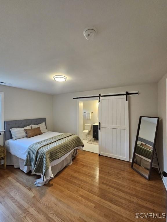 3109 Comet Rd, Richmond, VA 23294 - bedroom with visible vents, a barn door, wood finished floors, and ensuite bathroom