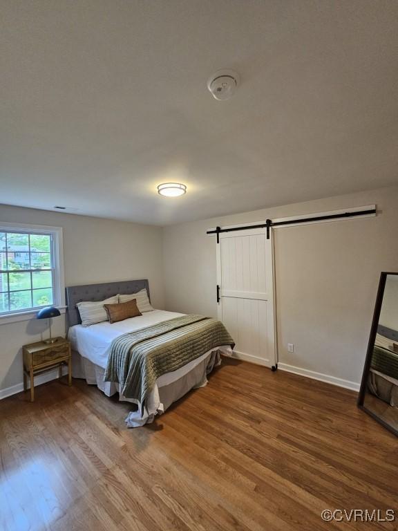 3109 Comet Rd, Richmond, VA 23294 - bedroom featuring baseboards, a barn door, and wood finished floors